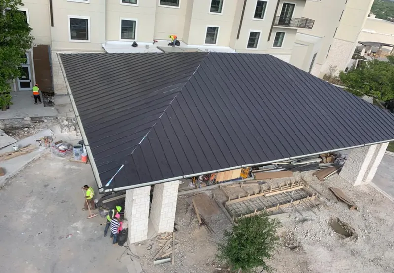 Metal roofing installation team working on a commercial building in Baldwin